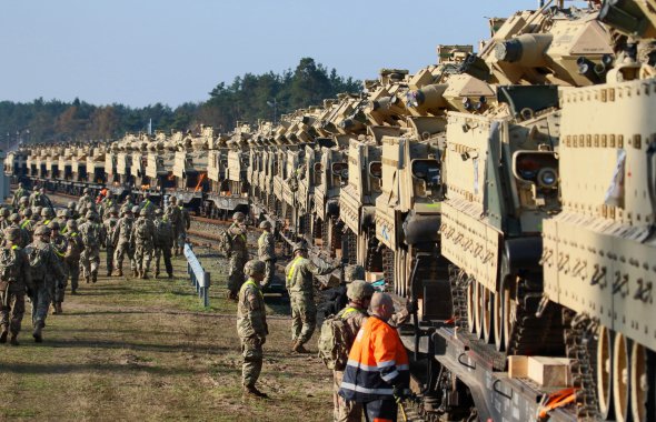 Военные США разгружают тяжелую боевую технику на железнодорожной станции у военной базы Пабраде в Литве 21 октября 2019 года. В частности, танки "Абрамс" и боевые машины "Брэдли". Photo by PETRAS MALUKAS/AFP с помощью Getty Images