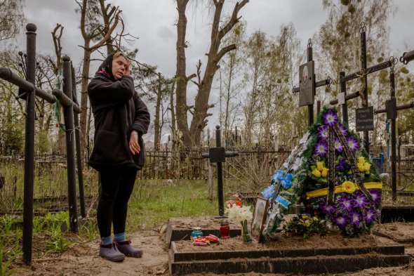 Ирина Абрамова у могилы мужа Олега, убитого российскими солдатами возле его дома в Буче 