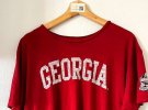 На аукцион выставят красную футболку исполнителя с белой надписью Georgia