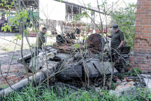 Нацгвардійці оглядають залишки російського танка у Копилові 