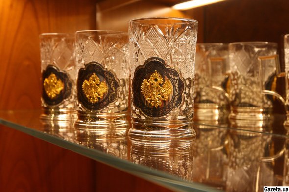 В барной зоне на хрустальных стаканах эмблема с изображением двуглавого орла, напоминающая герб России
