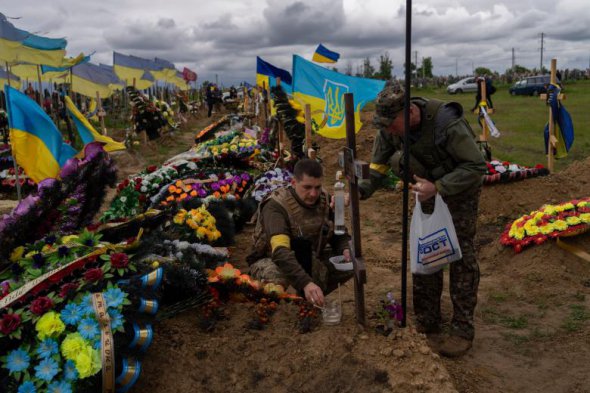 Двоє нацгвардійців відвідують могилу загиблого солдата на Харківському цвинтарі 
