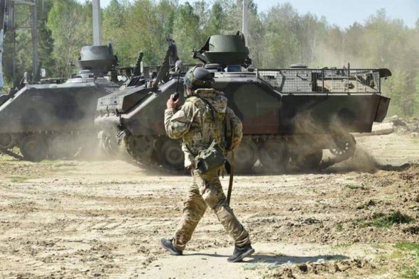 Український військовий проходить повз гусеничний бронетранспортер М113. Таку техніку наші воїни отримали від Нідерландів.