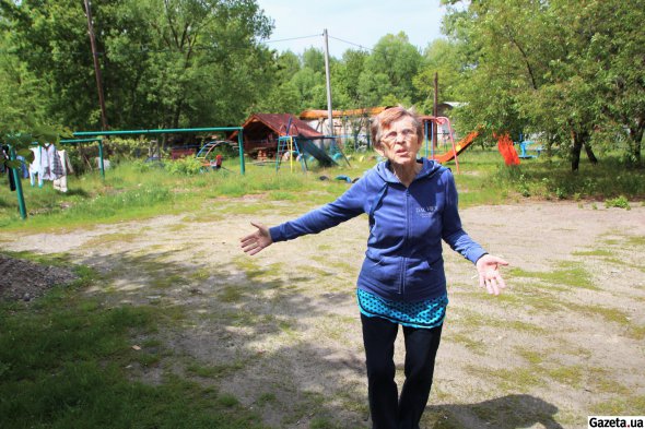 71-летняя Галина Попова во дворе выжженной многоэтажки рассказывает, как им с мужем удалось пережить месяц российской оккупации в Тростянце
