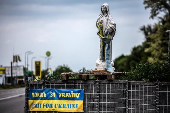 На дорозі між Дніпром та Покровськом статуя Діви Марії з українським прапором біля військового посту 28 травня 
