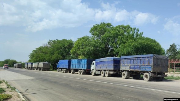 Колона вантажівок у селищі Жовтневе на узбіччі траси Джанкой – Сімферополь