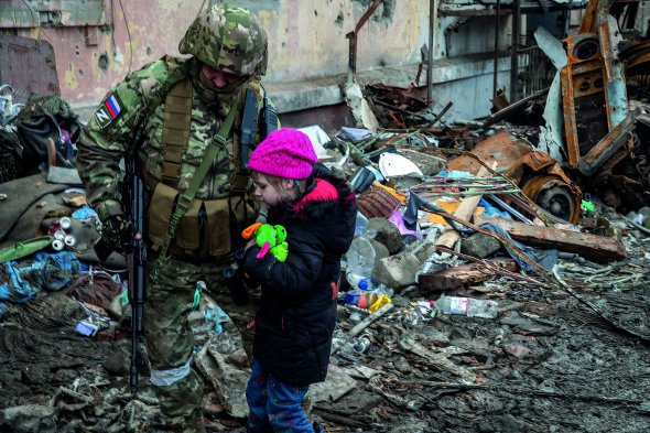 Російський загарбник вивів українську дівчинку з бомбосховища, де вона понад місяць переховувалася з рідними. 14 квітня 2022 року, Маріуполь, Донецька область