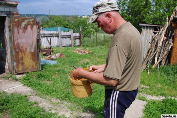 Валентин Ус показує гільзи, які зібрав на своєму подвір'ї - тут росіяни розташовували свої вогневі позиції