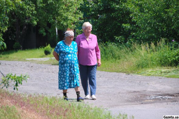 73-річна Валентина пересділа окупацію у своєї сусідки - 84-річної тезки. Жінки йдуть на поминальний обід до сусідів