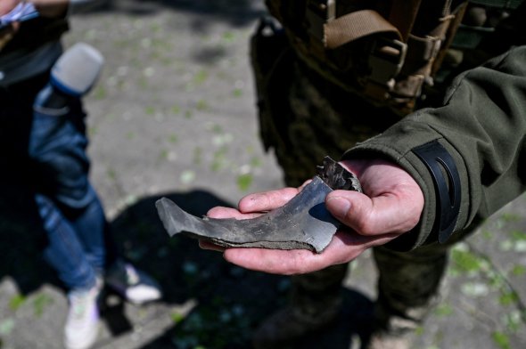 Военный показывает осколки снаряда, которые нашли после одной из атак оккупантов по Запорожской области 
