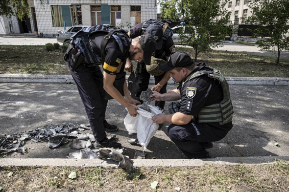 Працівники поліції збирають уламки ракети в місті Дружківка Донецької області. Вранці 9 липня росіяни випустили по населеному пункту чотири снаряди. Знищили місцевий торговельний центр, пошкодили будинок культури та житлові багатоповерхівки