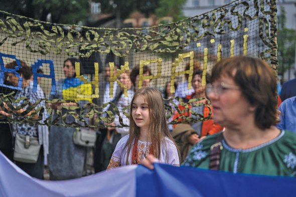 Люди тримають прапори під час церемонії перейменування території в польському Кракові між вулицею Кроводерською і сквером Біборського на сквер Вільної України  12 липня.