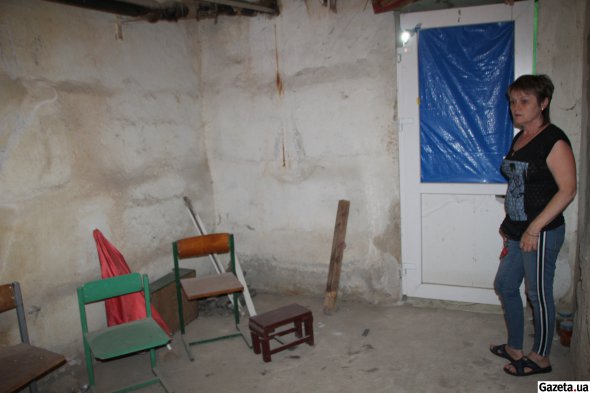 Світлана показує бомбосховище, яке облаштували мешканці кількох будинків у підвали, щоб ховатися від російських обстрілів
