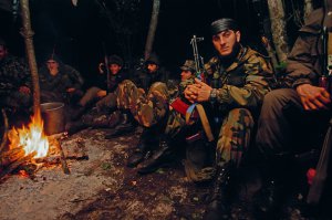 Чеченські військові гріються біля вогнища у сховку. 1 жовтня 1999 року