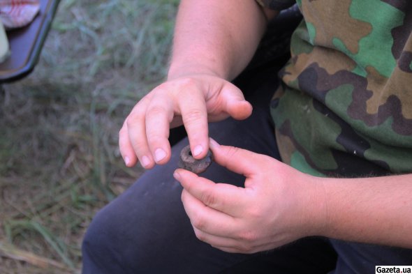 Олег Шапорда показывает глиняное прясло скифского времени, найденное на раскопках