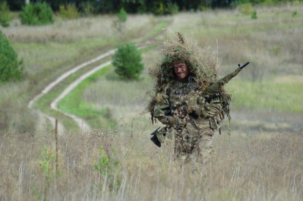 Фото зі зйомок екшену ”Снайпер. Білий ворон”, зроблене неподалік села Старе Бориспільського району Київської області 28 вересня 2020 року. Актор Павло Алдошин іде в тактичному маскувальному халаті, тримає снайперську гвинтівку Драгунова з покращеною оптикою. У фільмі втілив екопоселенця Миколу з Горлівки, який став добровольцем після початку російської агресії на Донбасі. Стрічку показують в українських кінотеатрах із 24 серпня