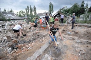 10-річний Ігор допомагає волонтерам розбирати завали власного будинку в Чернігові, 19 серпня. З лютого російські терористи невпинно бомбардували місто артилерією та авіацією. Зруйнували близько чверті його території. Витіснити загарбників із Чернігівщини вдалося лише у квітні. Відтоді в місті триває масштабна робота з розбирання завалів і розмінувань