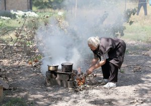 Жінка готує їжу на багатті біля свого зруйнованого будинку в місті Авдіївка Донецької області, 18 серпня. Російські окупанти постійно штурмують населений пункт. Більшість місцевих евакуювалися. Люди, які не встигли це зробити, мусять виживати. Через обстріли в’їзду в місто волонтери не можуть доставити продукти, ліки та воду