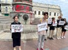 Горожане собрались вокруг монумента на акцию протеста. Принесли плакаты с надписями "Катерина = Путин", "Снести", "Убийца"