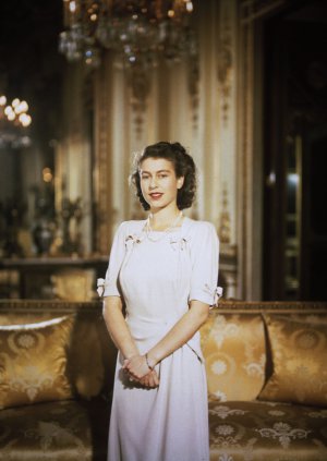 Принцеса 21-річна Єлизавета стоїть у Букінгемському палаці в Лондоні, Велика Британія, під час заручин із герцогом Единбурзьким Філіпом у липні 1947-го. Побралися в листопаді
