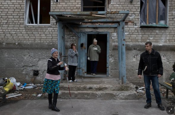 Жители возле поврежденного дома в Бахмуте. Русские обстреливают город уже три месяца 