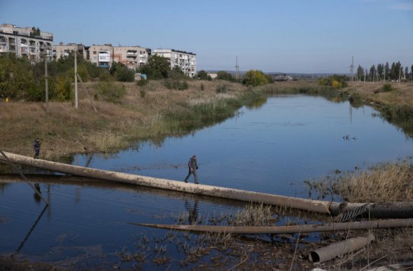 Чоловік йде газовою трубою в Бахмуті 