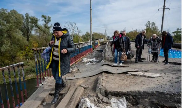 Люди бегут на запад по сильно поврежденному мосту через реку Оскол 