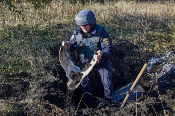 Співробітник служби надзвичайних ситуацій тримає частину збитої російської ракети у вівторок у Харкові 