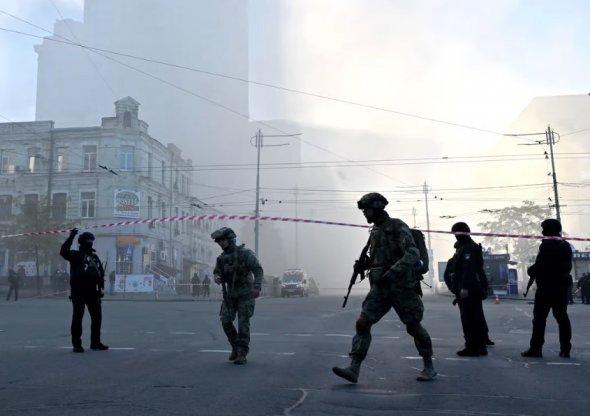 Українські військові та поліцейські на вулиці після атаки дрона у Києві 