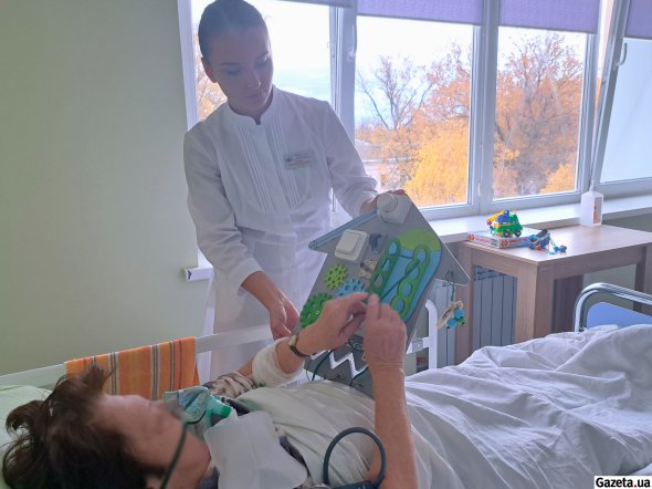 Эрготерапевт Евгения Скрильник проводит занятия с пациенткой