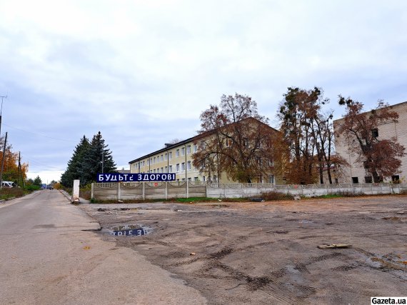 В'їзд на територію Ізюмської лікарні. Відвідувачів зустрічає табличка "Будьте здорові" з частково пошкодженими літерами