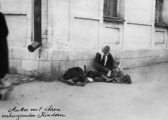 Жінка зі своїми голодними дітьми сидить на вулиці в Харкові, 1933 рік