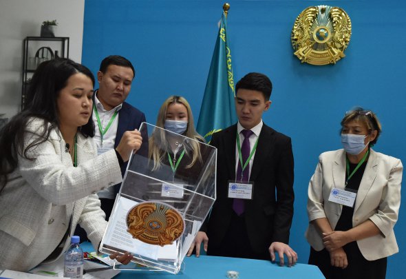 Члены избирательной комиссии высыпают бюллетени с урны для голосования на участке после президентских выборов в Казахстане в Астане 20 ноября.