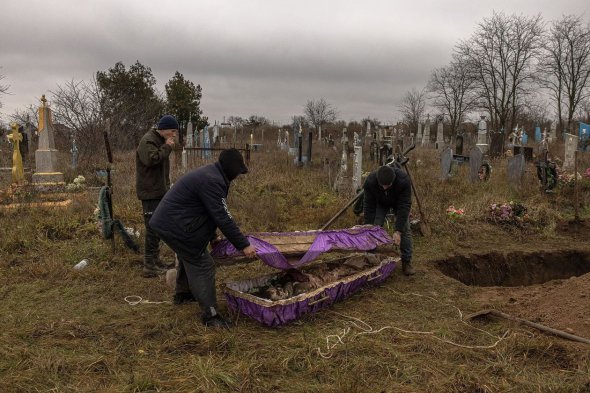 Місцеві жителі закривають труну з ексгумованими останками 15-річної дівчинки недалеко від Херсона 