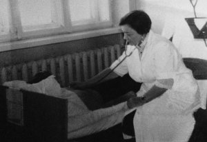 Лікарка-гематолог Ярослава Виговська оглядає хворого в зеніті своєї кар‘єри. З 1953 року і дотепер працює в Інституті патології крові та трансфузійної медицини Національної академії медичних наук України у Львові. Є однією з творців української наукової школи в галузі гематології. До 40 років стала доктором наук, захистила дві дисертації, завідувала відділом. Згодом отримала звання професора