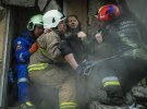 Спасатели ГСЧС выносят Екатерину из-под завалов дома, куда попала российская ракета. Судьба ее мужа и сына неизвестна