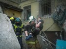 Рятувальники ДСНС виносять Катерину з-під завалів будинку, куди влучила російська ракета. Доля її чоловіка та сина невідома