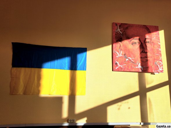 На стіні у кімнаті переговорів "Творчих майстерень" висить прапор України та картина Геннадія Мироненка "Григорій Сковорода"