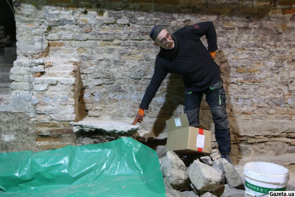 Тимур Бобровський показує рівень підлоги, який був у підвалі до початку розкопок