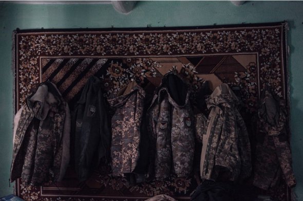 Військові куртки на стіні сільського будинку, що тимчасово використовується українськими військами як база на сході України 