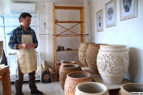 Юрій Пошивайло показує свою роботу - садову композицію з великих ваз, якою прикрасять територію музею-заповідника