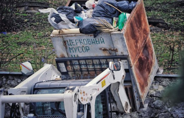 Екскаватор перевертає сміттєві баки поряд із Києво-Печерською лаврою у столиці в середині березня 2023 року
