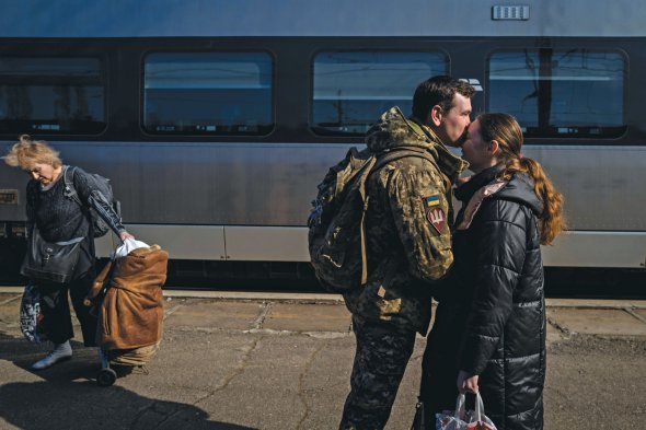 Жінка зустрічає військового біля потяга з Донецької області на вокзалі в Києві 22 березня 2023 року