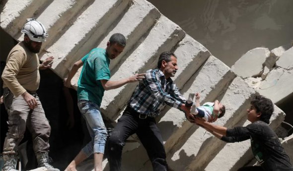 Спасатели извлекают ребенка из-под обломков разрушенного здания в Алеппо