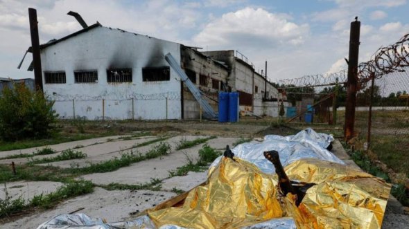 Тела погибших азовцев возле разбомбленного барака в фильтрационном лагере близ Еленовки утром 29 июля 2022 года