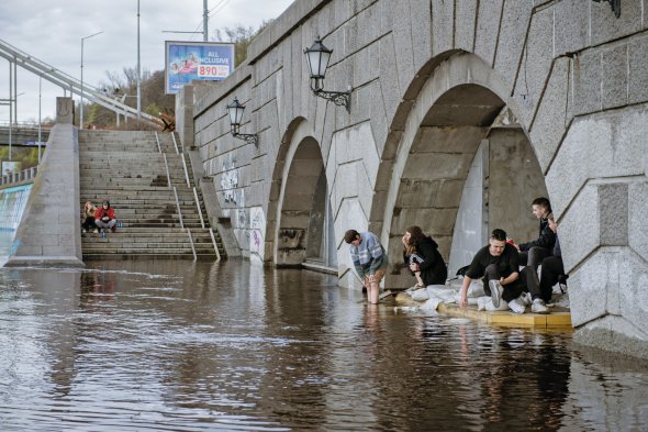 Люди полощуть взуття у Дніпрі в Києві 18 квітня. Річка вийшла з берегів – і затопило набережну й деякі райони міста. Синоптики попереджали 13 квітня про можливі повені в Київській і Чернігівській областях