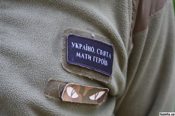 Шеврон на грудях Магді Захарі. Чоловік добре знає українські патріотичні гасла