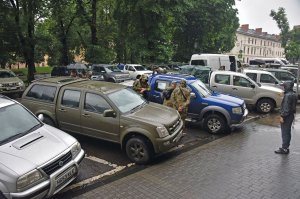 Українські військові оглядають позашляховики, які привезли британські фермери до Львова 17 червня 2023 року