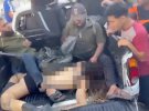 Молодая женщина с ранением головы лежит полуобнаженная в кузове грузовика. Ее окружают террористы ХАМАС