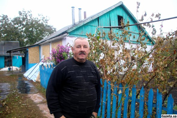 Василий Плетинка возле своего дома, поврежденного взрывной волной – их семья живет через дорогу от разрушенного кафе
